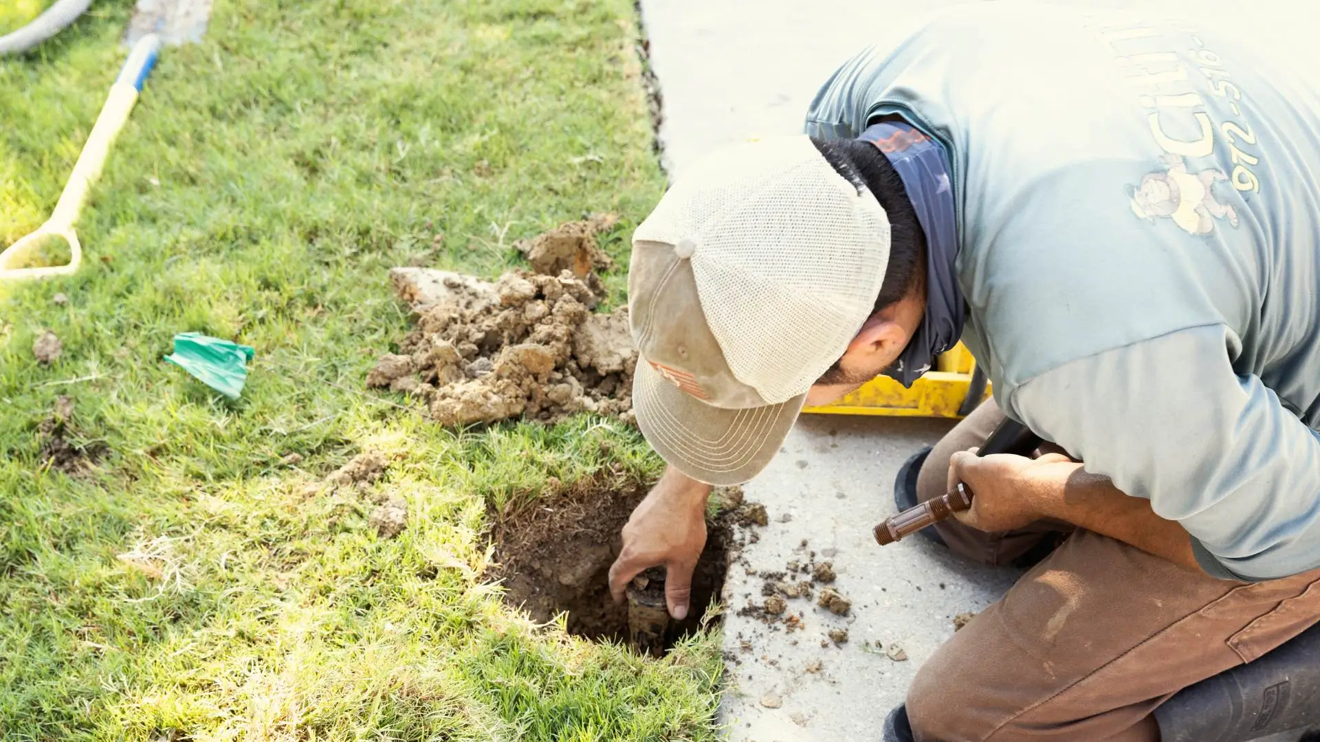 Cititurf professional repairing an irrigation system by walkway in Allen, TX.