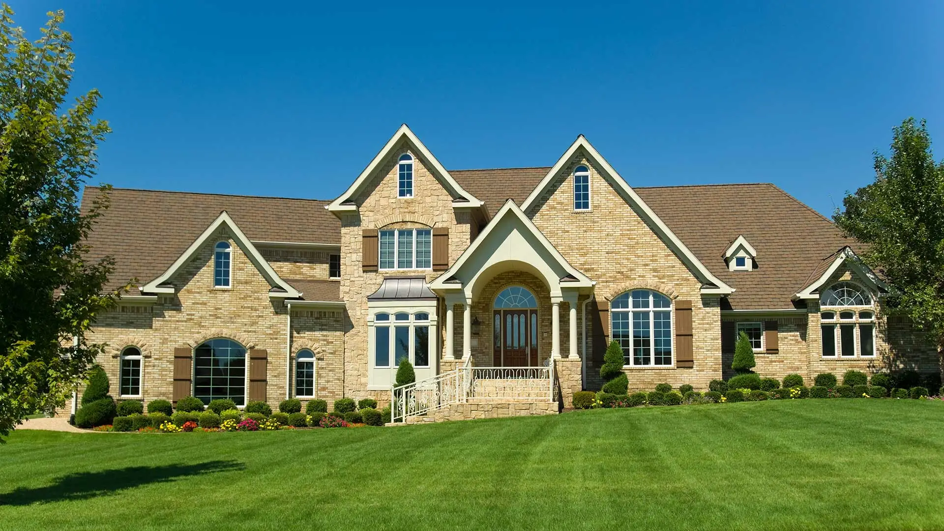 Flawless lawn and landscape at the front yard of a large brick home near Garland, TX.