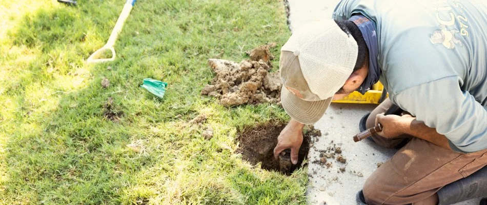 Person in Plano, TX, working on a sprinkler head.