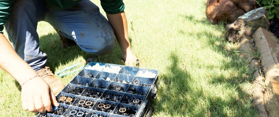 Professional choosing sprinkler head for irrigation system in Wylie, TX.