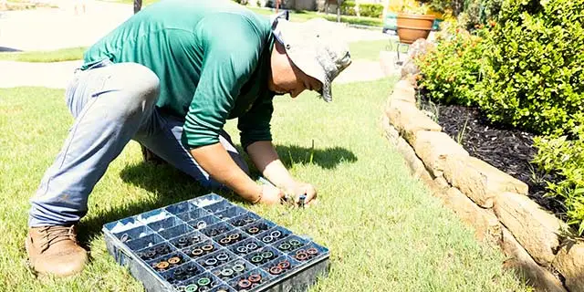 Irrigation expert replacing sprinklers at a home in The Colony, TX.